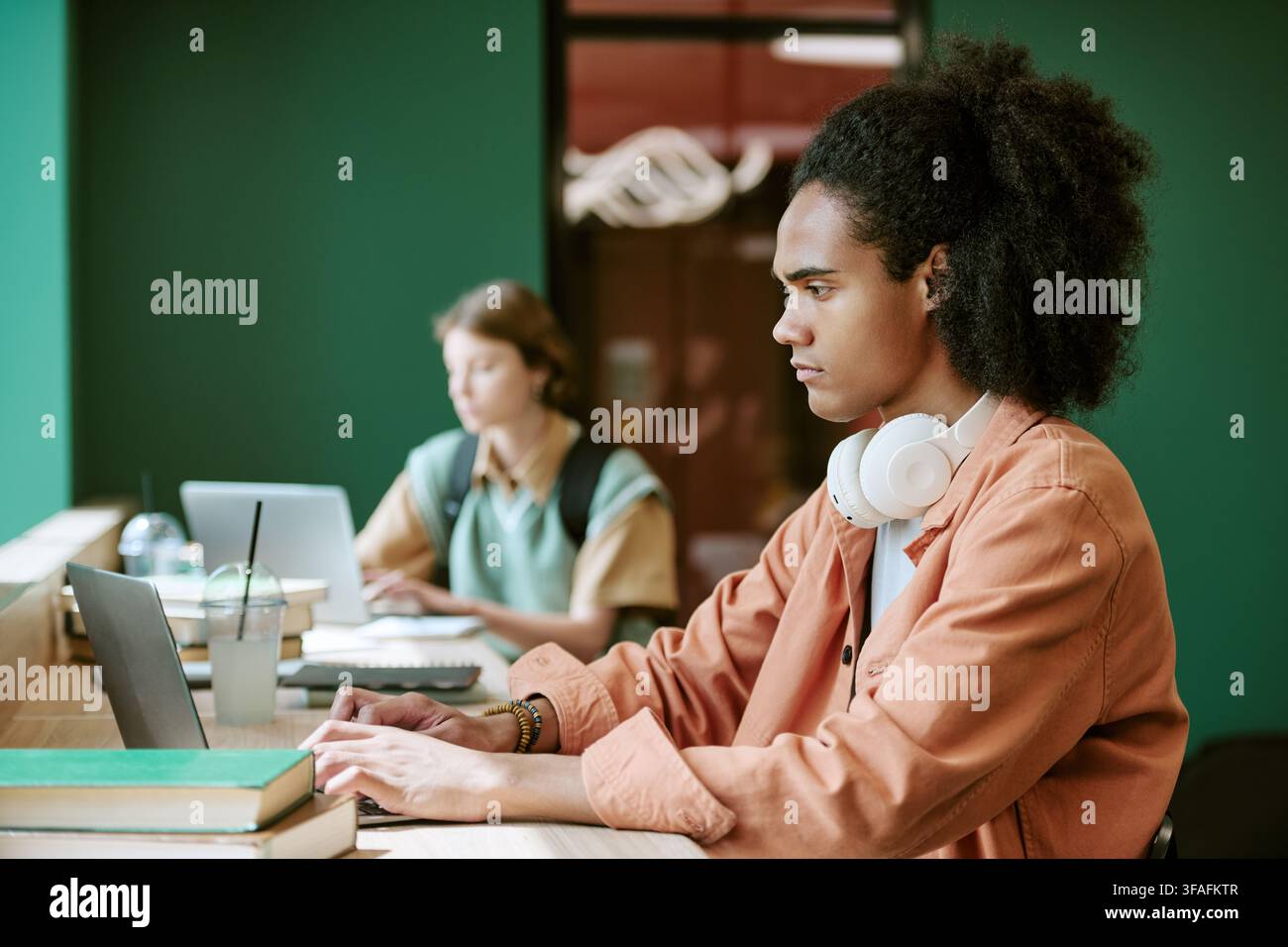 Diverse Students Studying on Laptops in University Campus Library Stock Photo