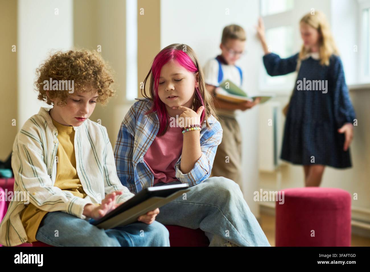 School Children Using Digital Tablet in Classroom Hallway Stock Photo