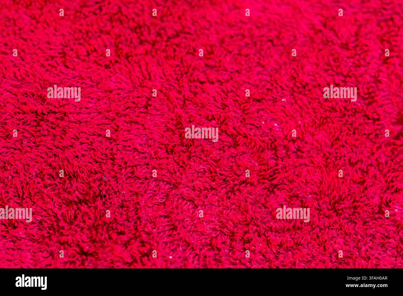 Closeup of a bright red fluffy carpet surface filling the entire frame. Stock Photo