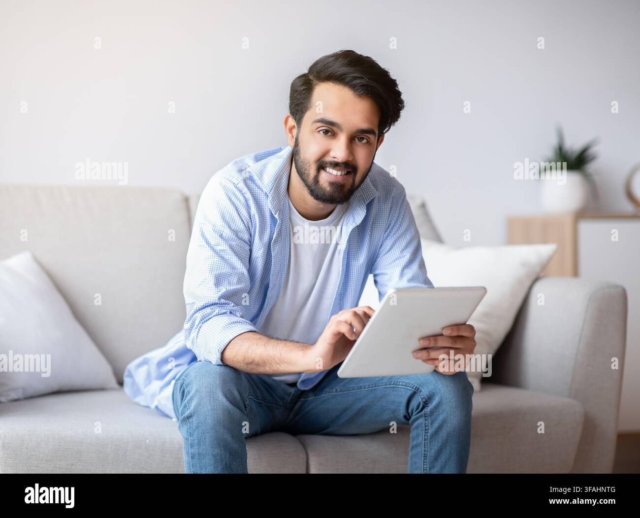 Handsome Young Arab Man Using Digital Tablet Computer At Home Stock Photo