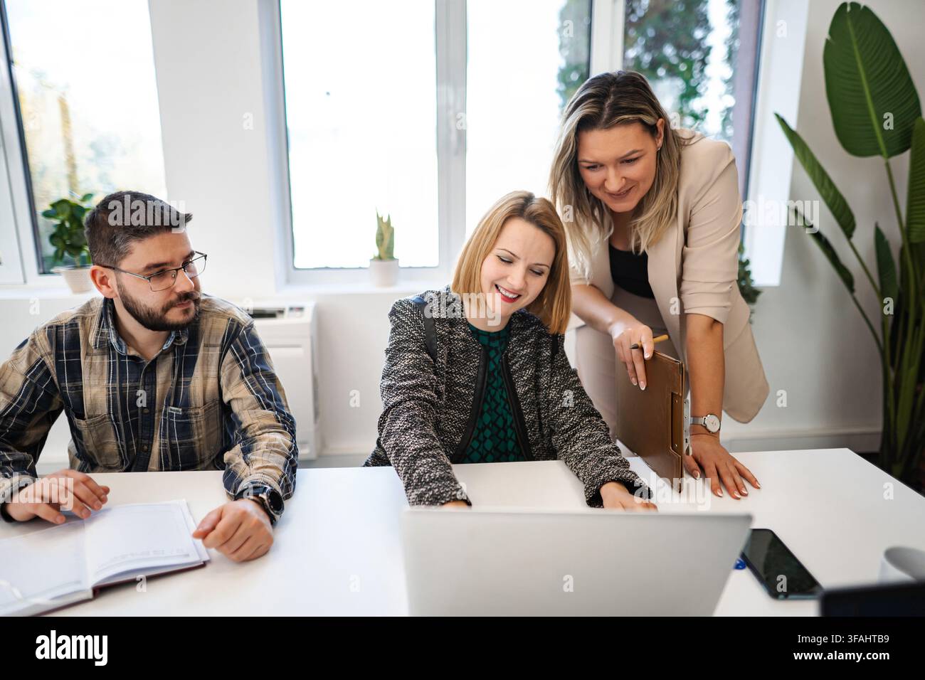 Business team collaborating on project using laptop in office Stock Photo