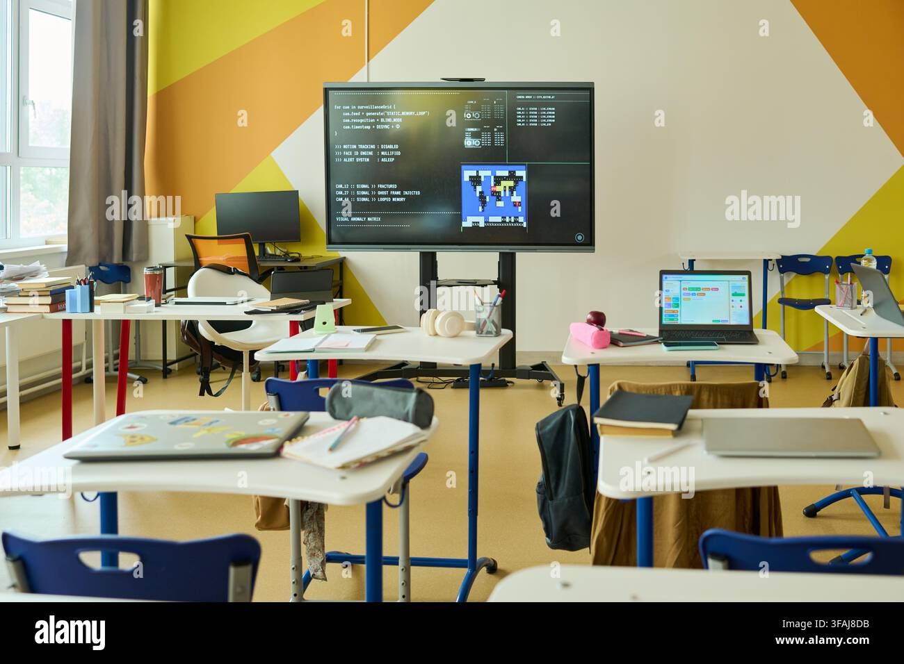 Empty Modern Classroom Displaying Coding Lesson on Interactive Screen Stock Photo