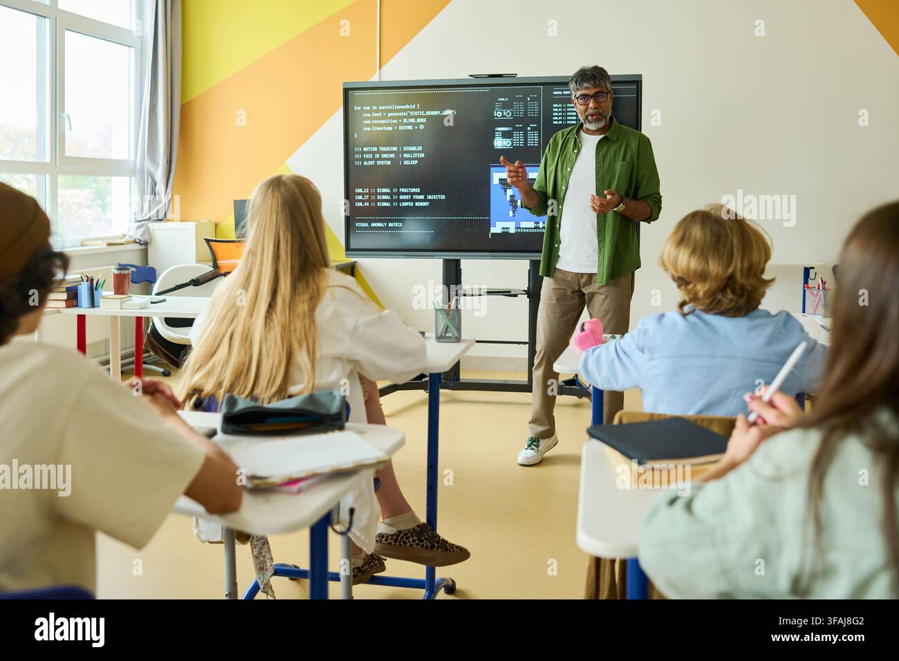 Indian Teacher Explaining Coding to Teenagers in Classroom Stock Photo