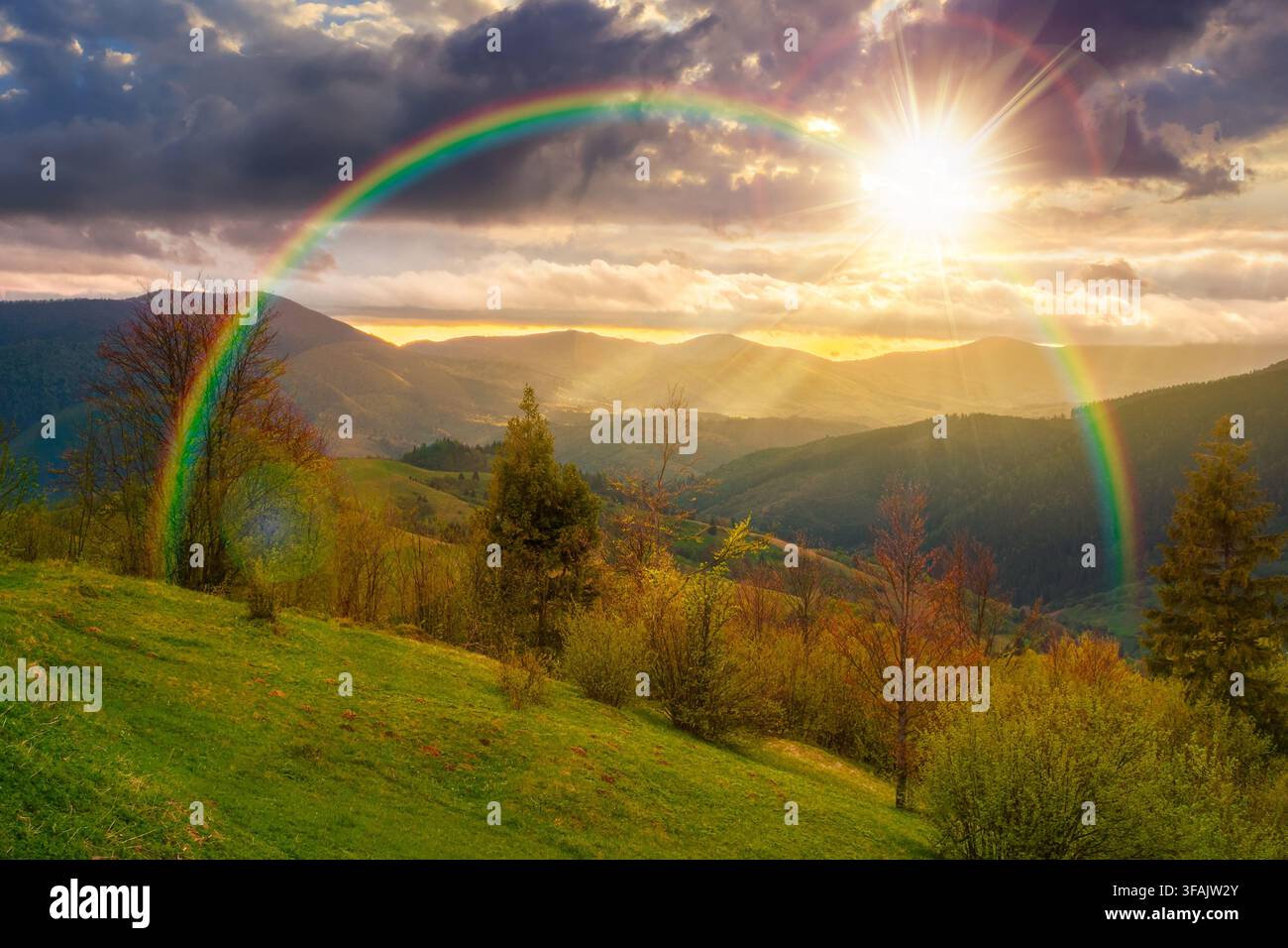 sunset over mountainous countryside scenery. cloudy sky view above the valley. green fields and trees on the hills. volatile nature scenery of carpath Stock Photo