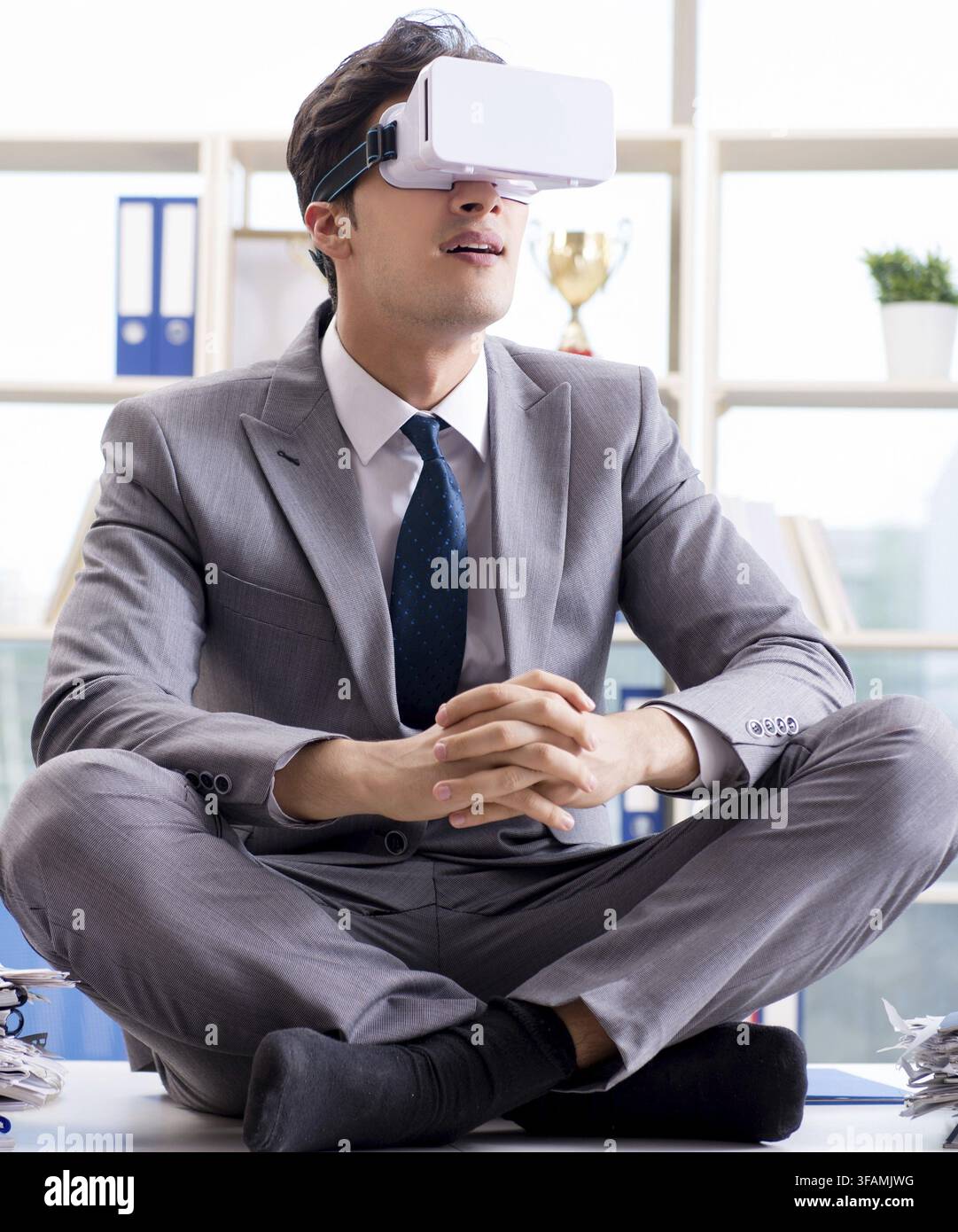 Businessman using VR virtual reality glasses in office Stock Photo