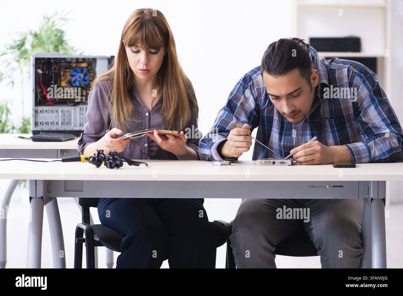 The two technicians who work in the computer warranty center Stock Photo