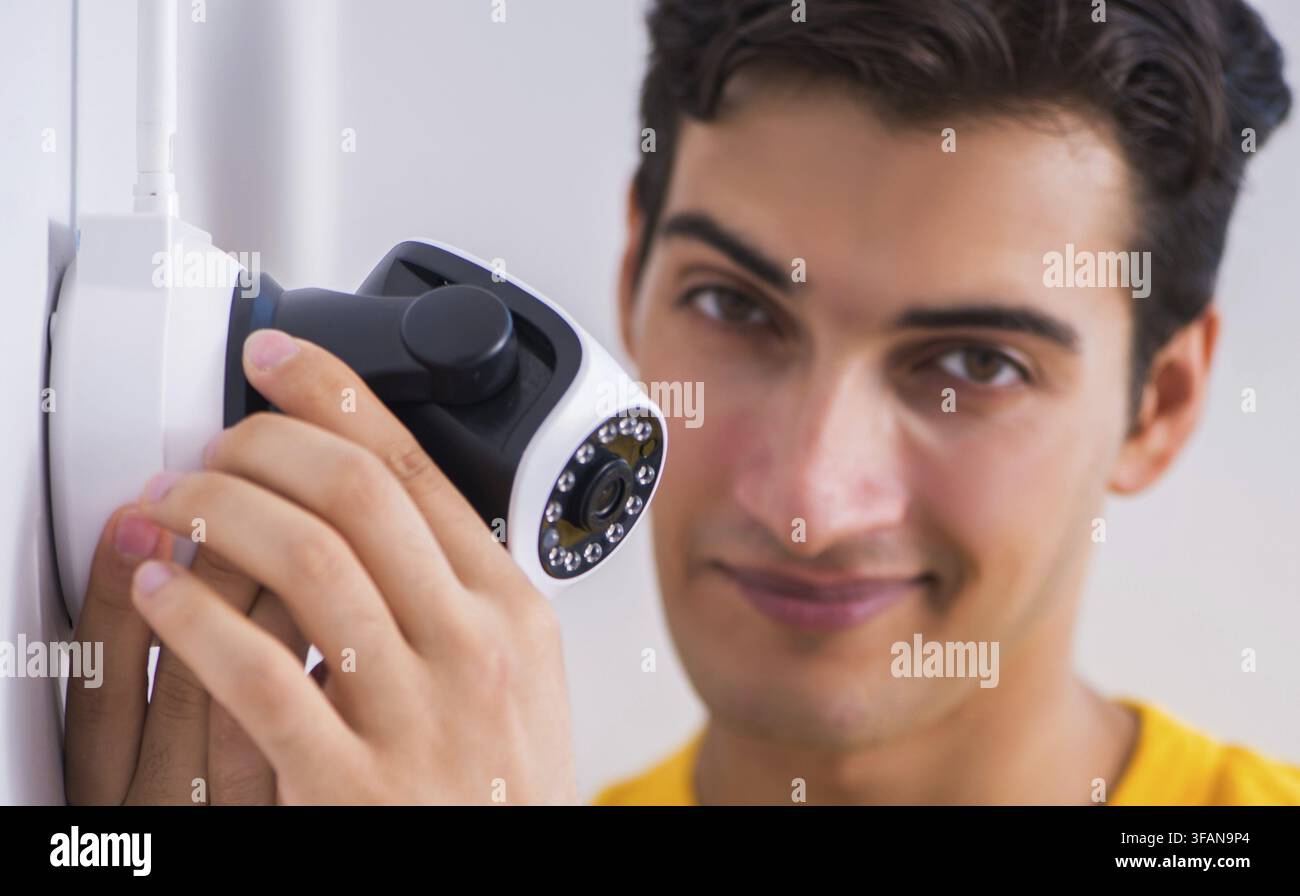 Contractor installs CCTV security cameras in office Stock Photo