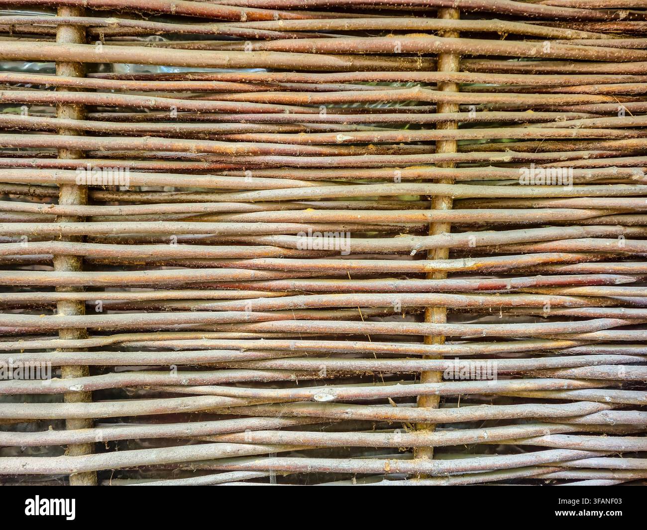 Close-up view of a traditional Ukrainian fence made from intertwined natural branches, showcasing its weathered texture and authentic craftsmanship Stock Photo