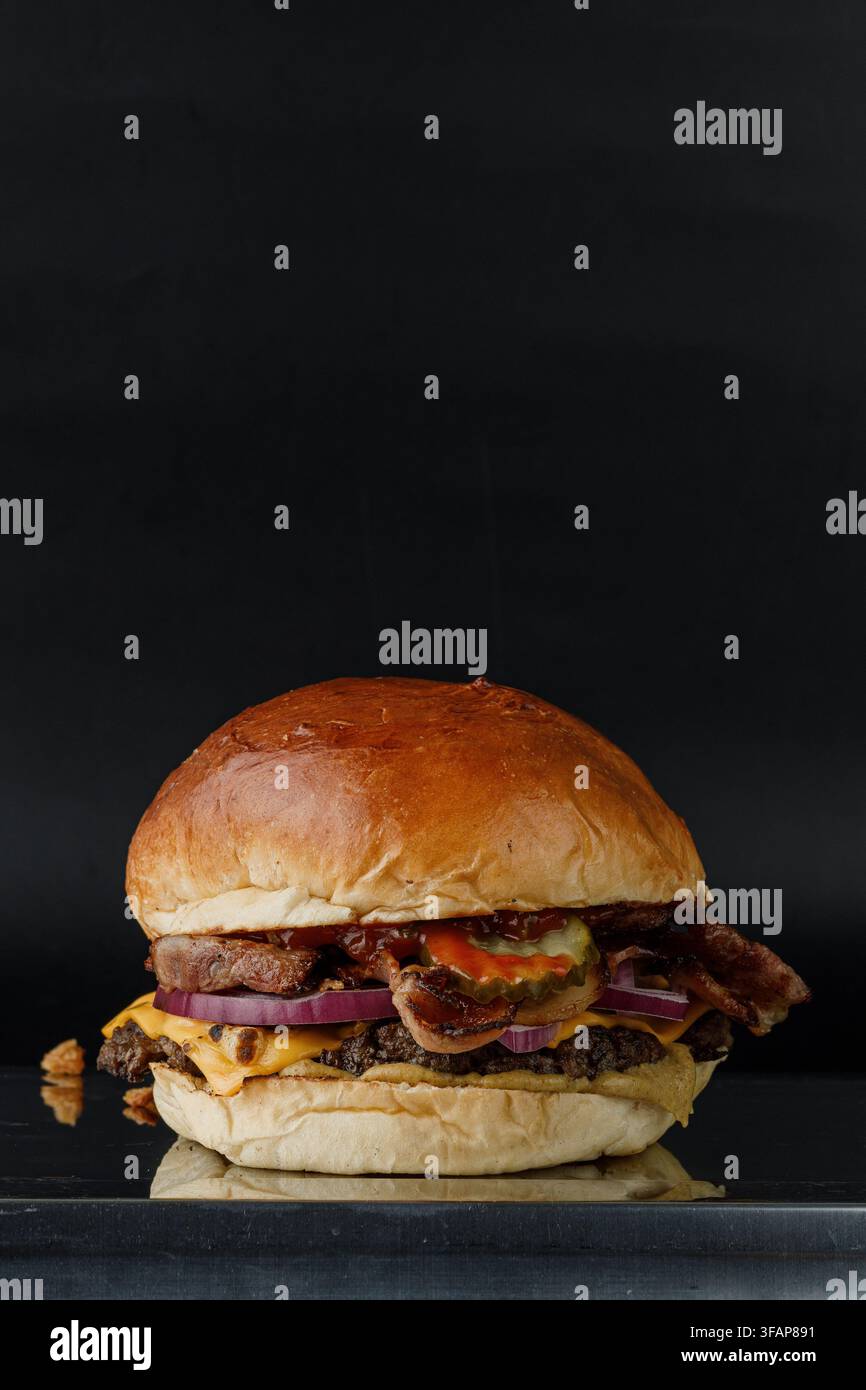 Loaded bacon cheeseburger on dark background Stock Photo