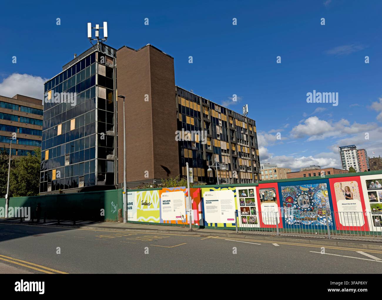 Charles House office block in Eccles, Salford, beside regeneration hoardings during redevelopment of the town centre in August 2026. Stock Photo