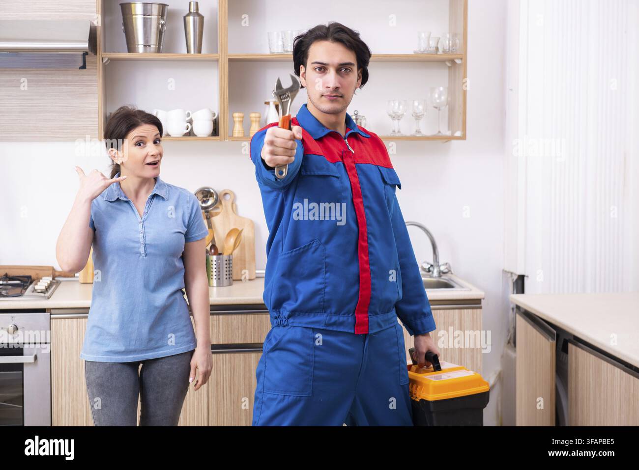 Young male mechanic repairs faucet Stock Photo