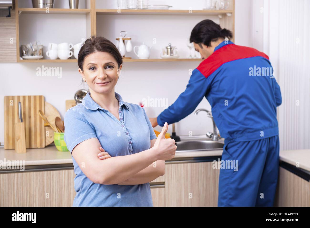 Young male mechanic repairs faucet Stock Photo