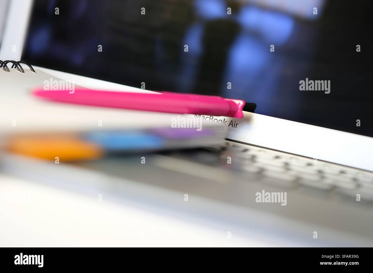 pen and notepad on laptop computer keyboard Stock Photo