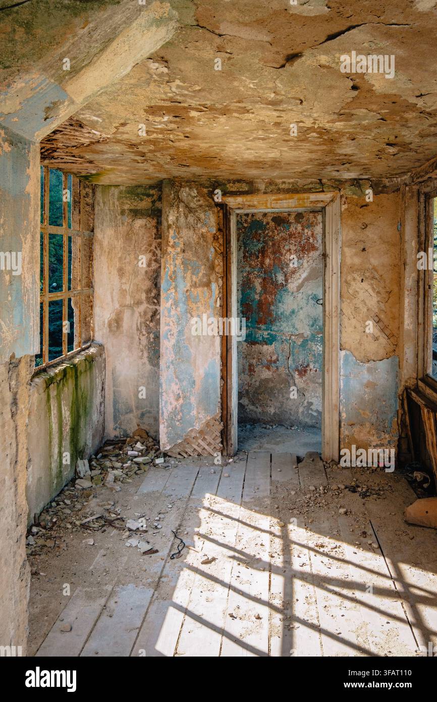 Sunlight casts geometric shadows across a decaying gallery inside Temur Maghradze Stadium in Chiatura, Georgia Stock Photo