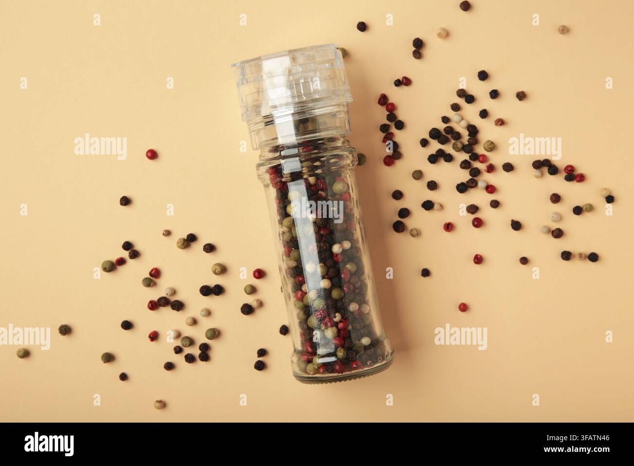 Plastic pepper mill on beige background. Top view Stock Photo