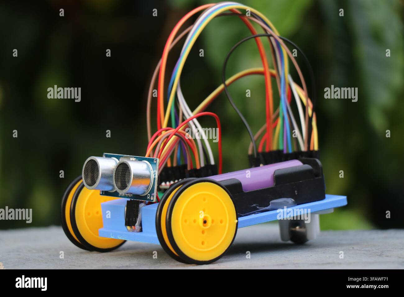 Programmable diy robotic car with obstacle sensor and small wheels powered by battery Stock Photo