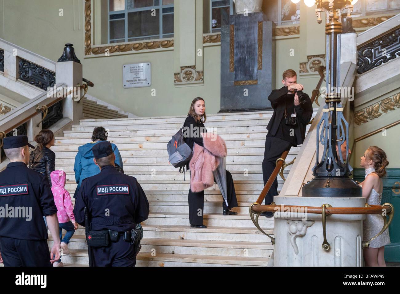 Saint Petersburg, Russia, 16 August 2026, Vitebsk railway station, Russian police officers in MVD uniform stand at base of marble staircase inside gra Stock Photo