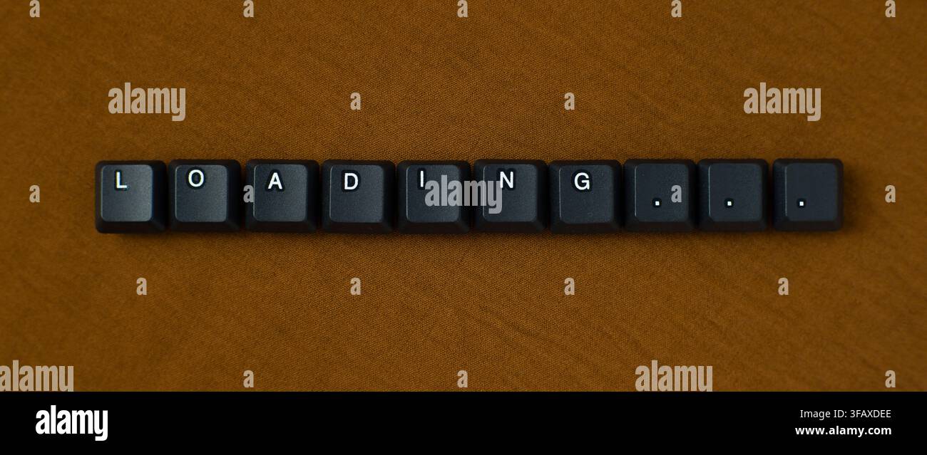 Loading Progress Message With Keyboard Keys On Brown Background Stock Photo