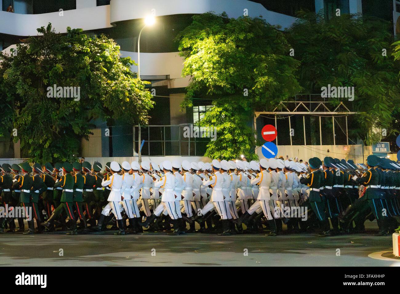 Honor guard soldiers marching in formation on Van Cao, Hanoi at night Stock Photo
