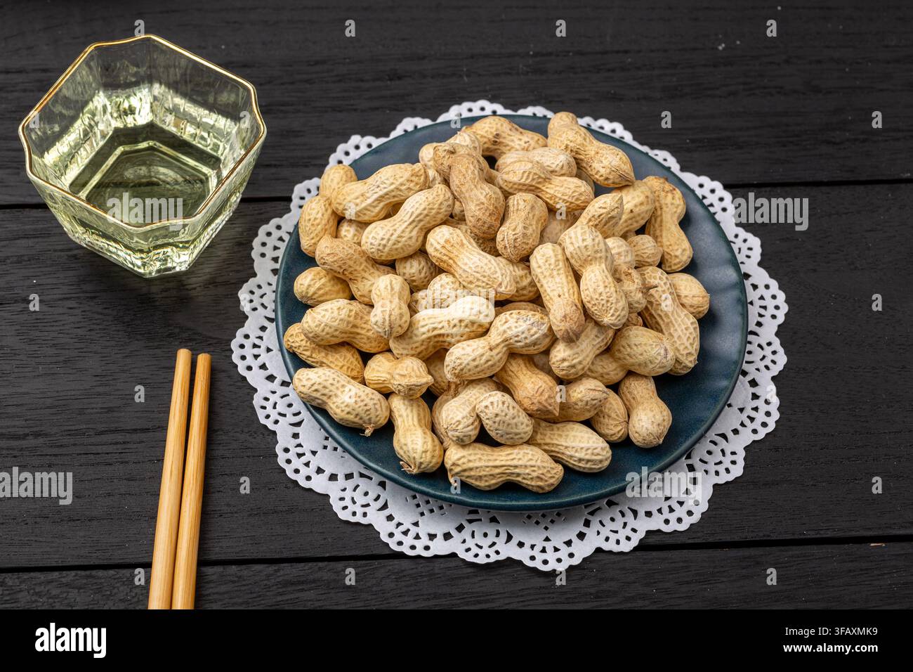 Roasted peanuts in shell served on blue dish Stock Photo