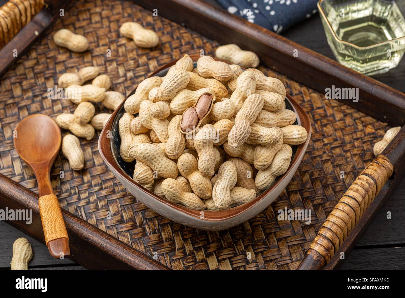 Roasted peanuts in shell served on blue dish Stock Photo