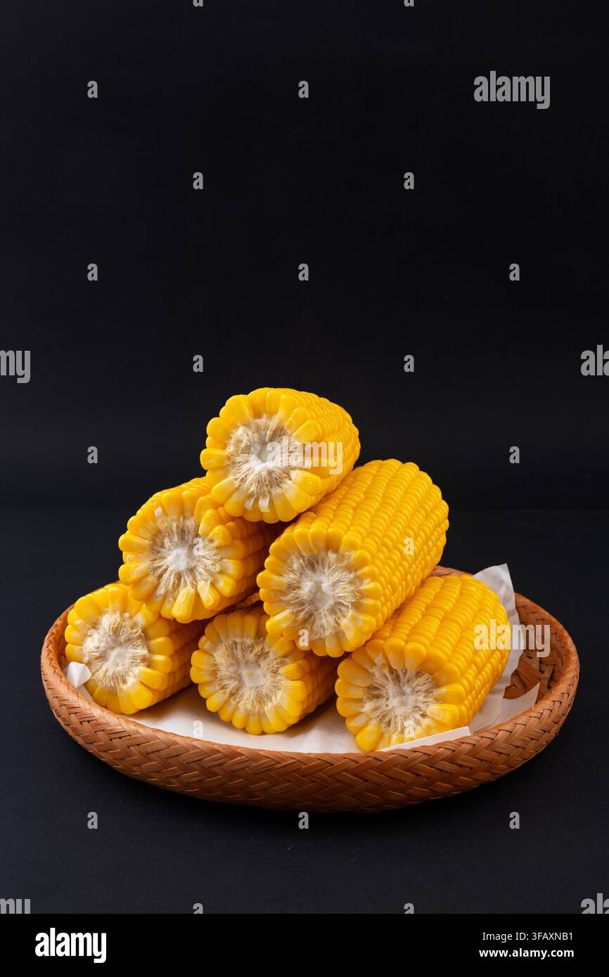 Boiled yellow waxy sweet corn cobs stack isolated on white background Stock Photo