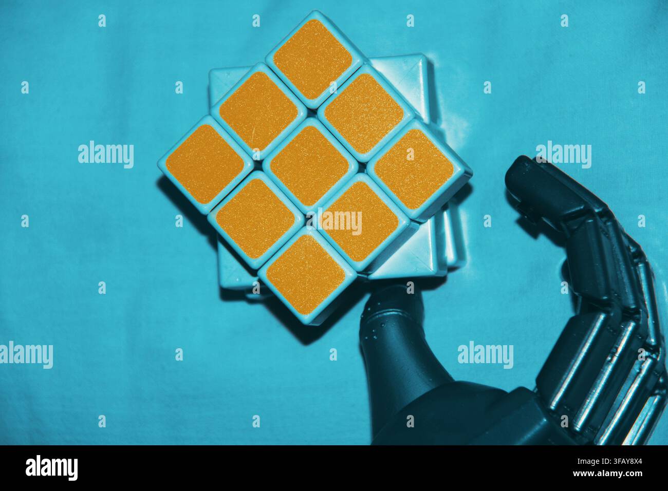 Robotic Hand Holding a Rubik’s Cube Stock Photo