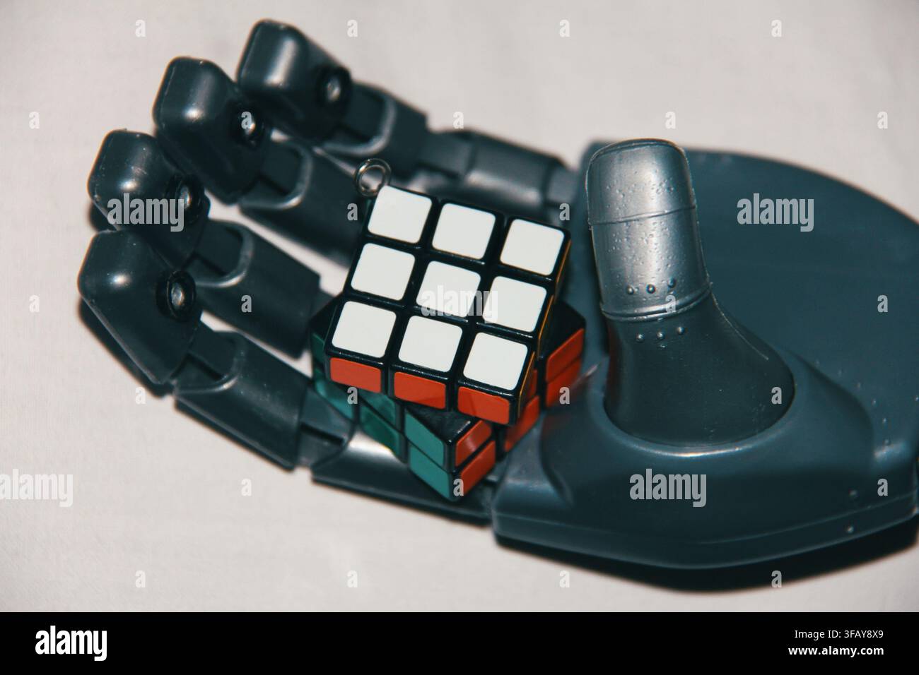 Blue Robotic Hand Holding a Rubik's Cube, Artificial Intelligence and Problem Solving Concept Stock Photo