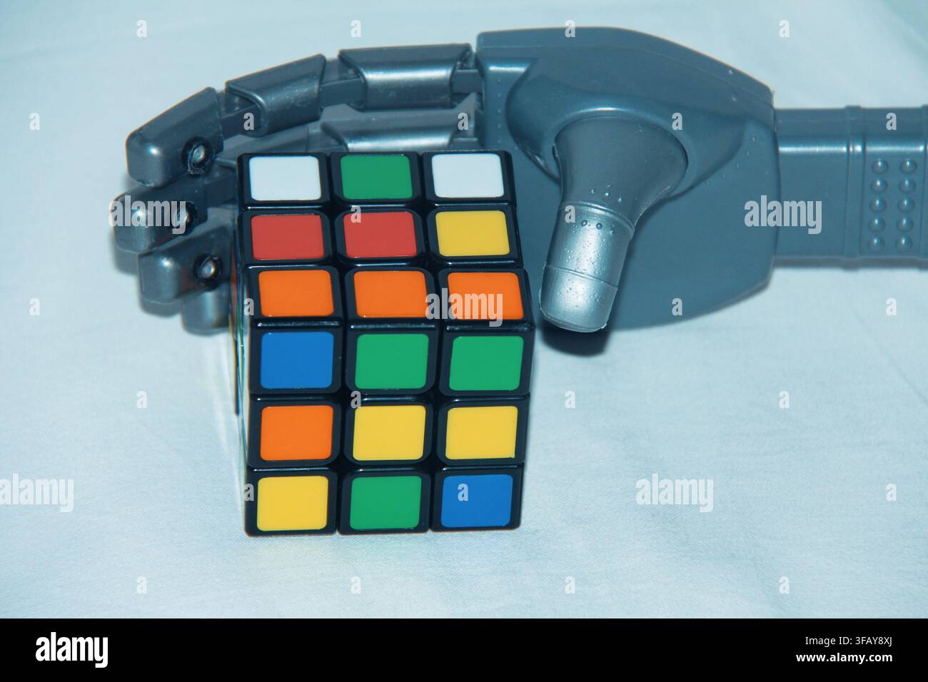 Blue Robotic Hand Holding Rubik's Cube, Artificial Intelligence and Problem Solving Concept Stock Photo