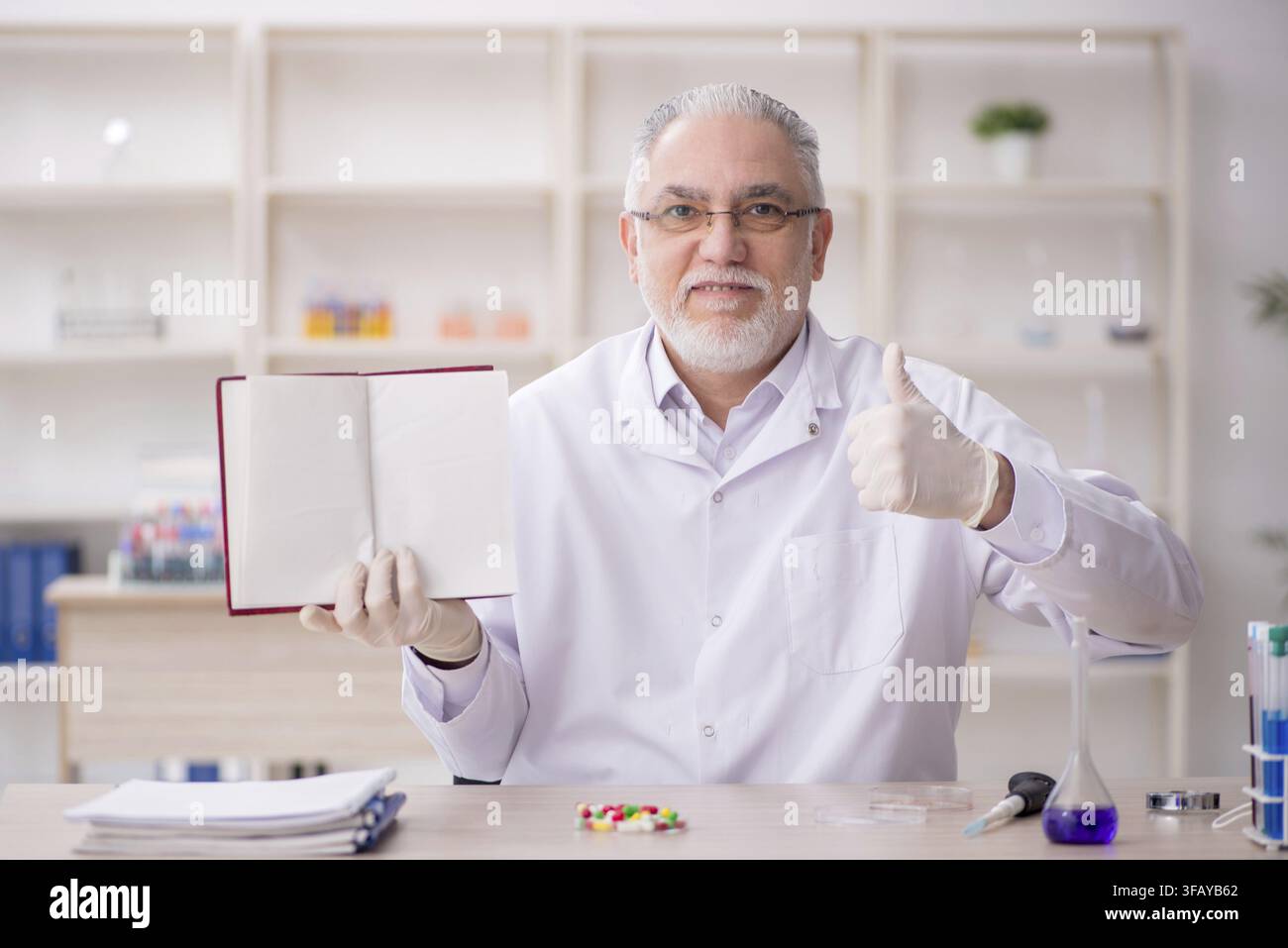 Old chemist working in laboratory Stock Photo