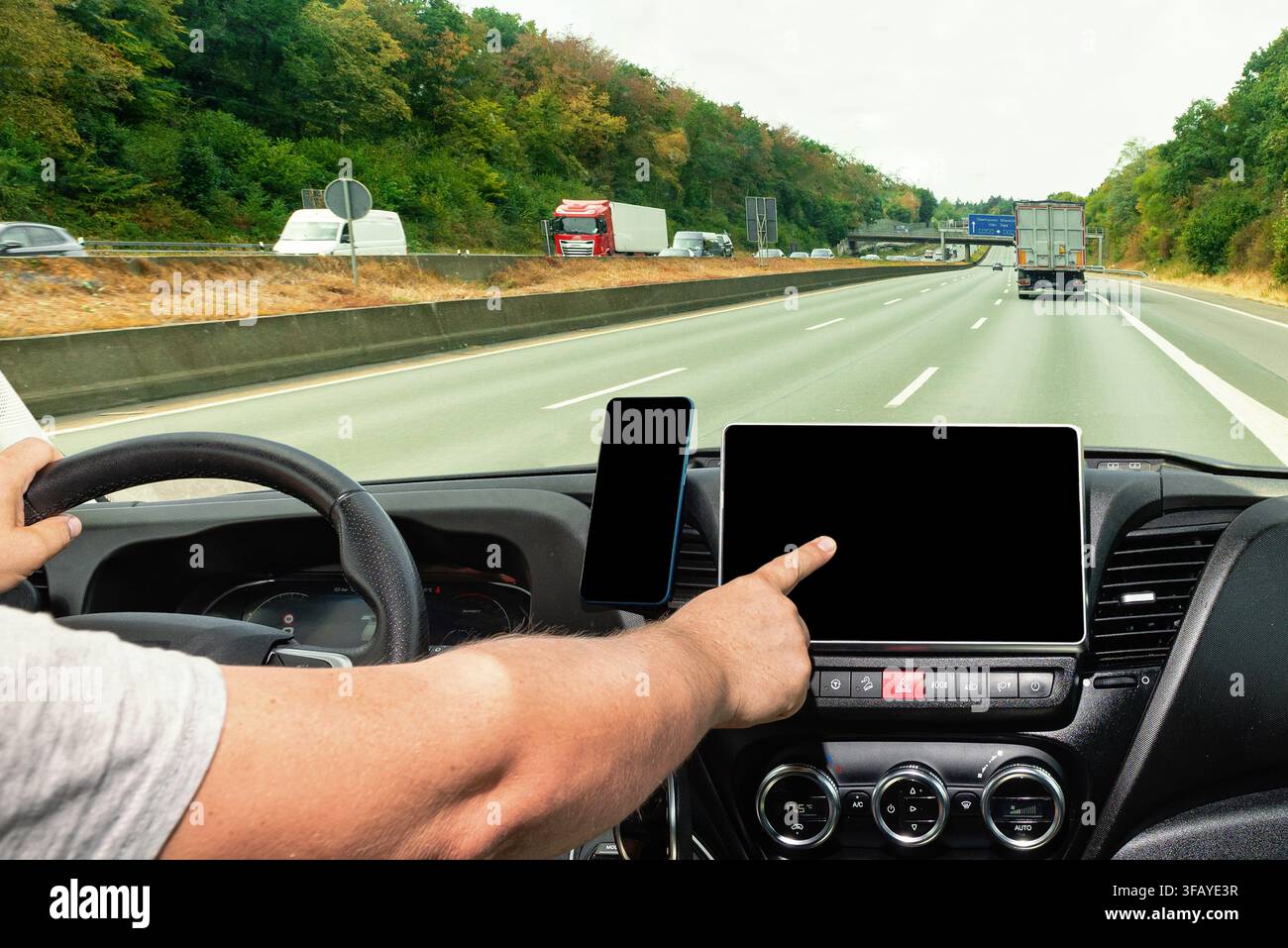 Close up of a man using navigation or infotainment digital dashboard system during a vehicle trip Stock Photo