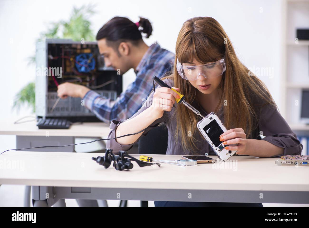 The two technicians who work in the computer warranty center Stock Photo