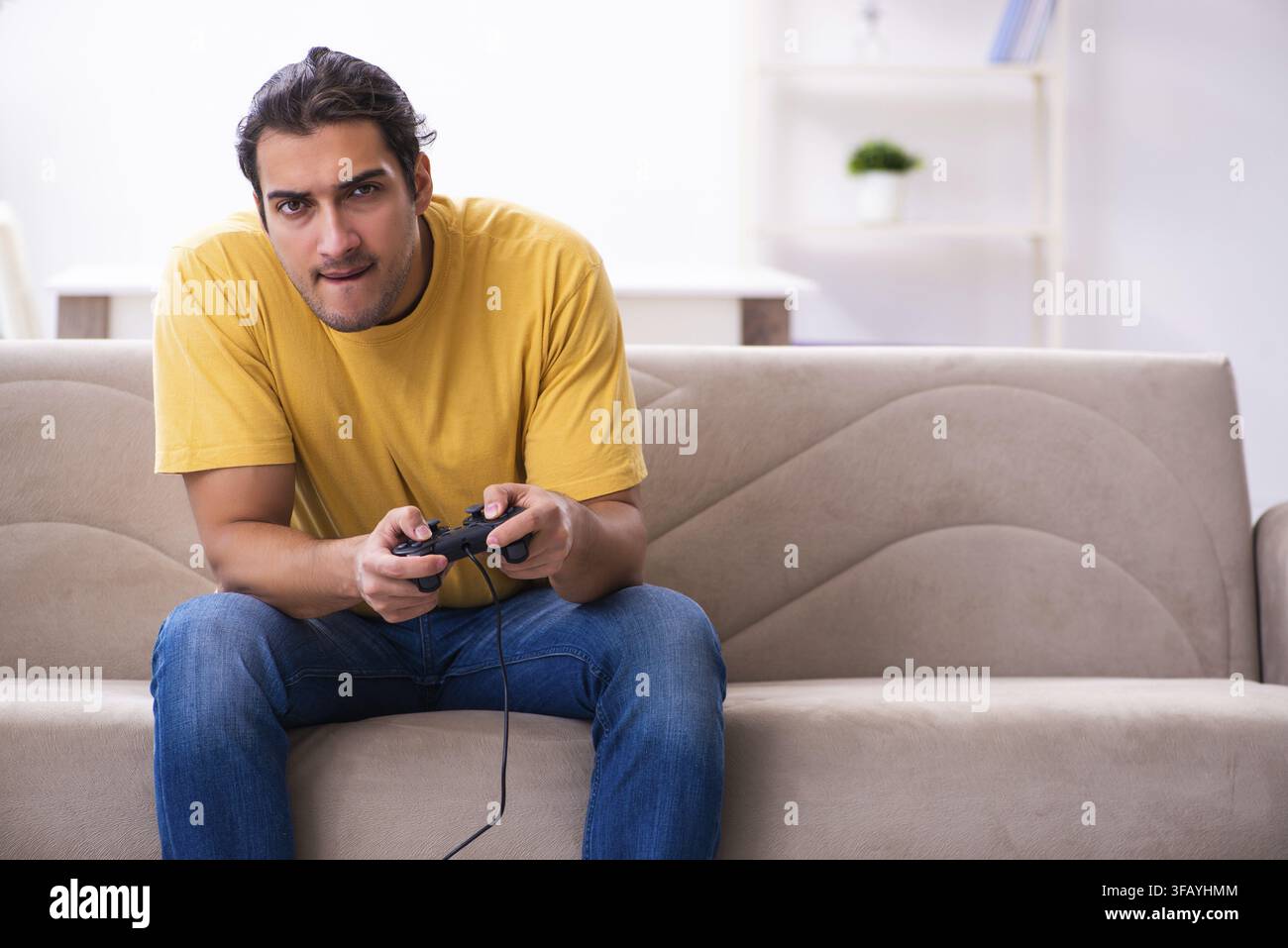 Young man playing joystick games at home Stock Photo