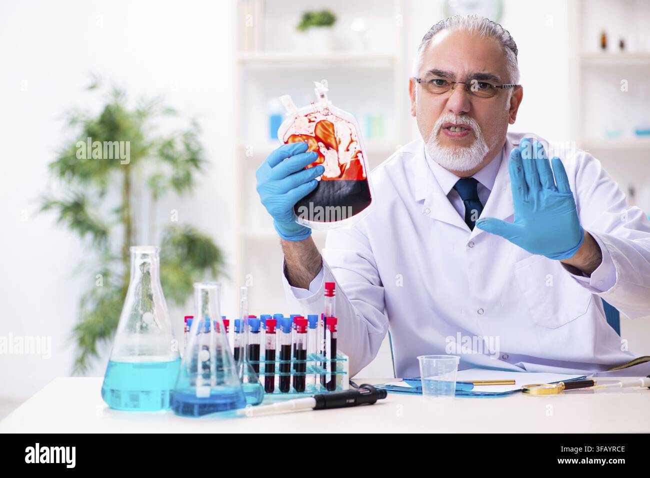 Old chemist working in laboratory Stock Photo