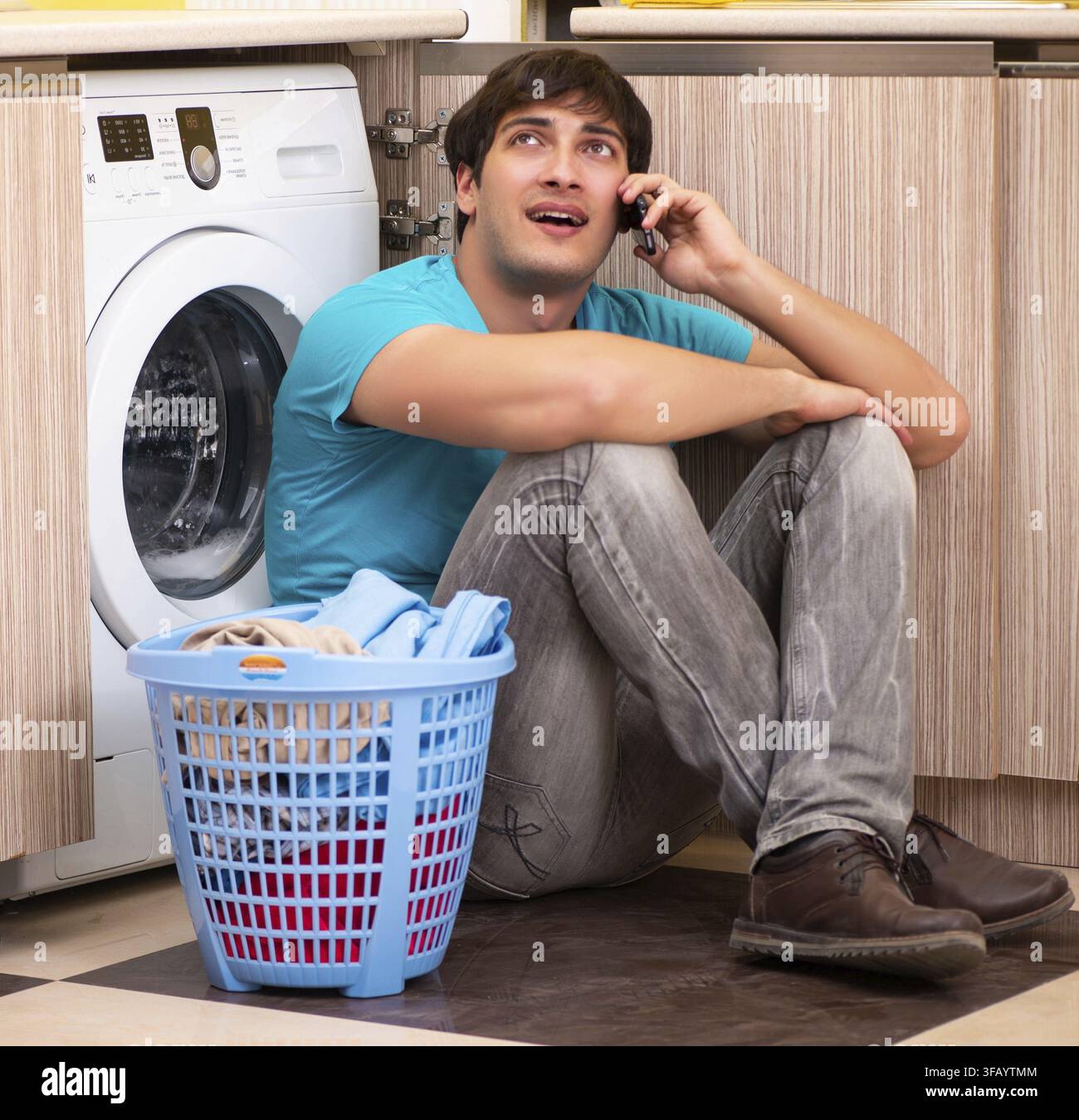 The young man doing laundry at home Stock Photo