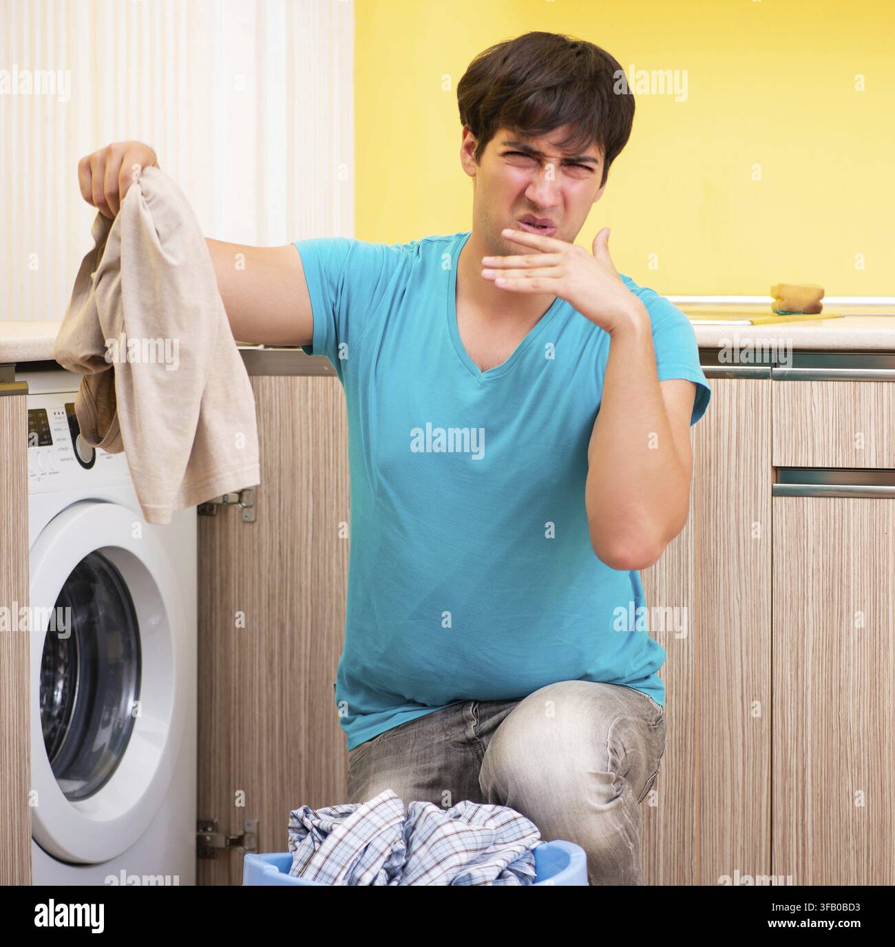 The young man doing laundry at home Stock Photo