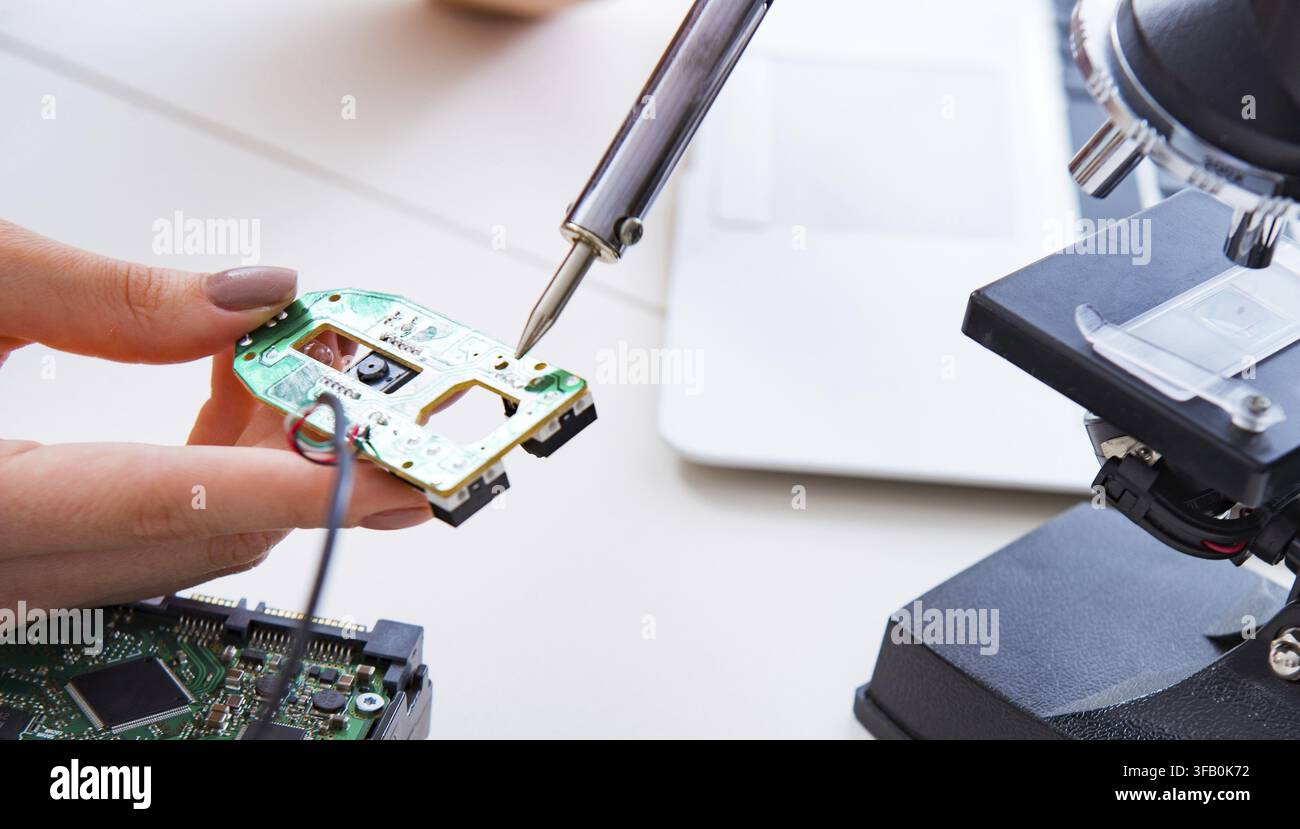 The engineer repairs a broken computer hard drive Stock Photo