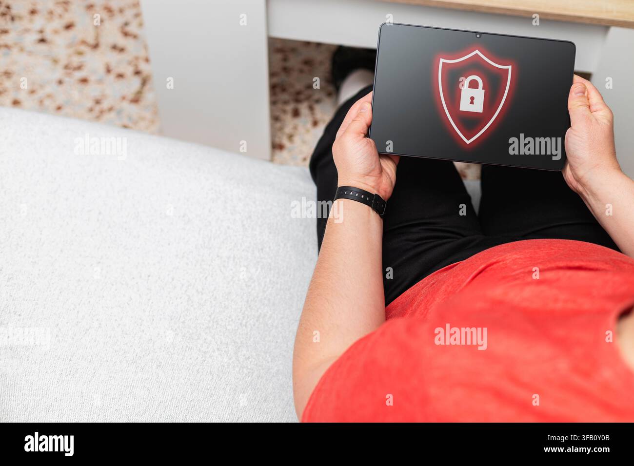 Person using tablet displaying shield and lock icon, symbolizing digital data protection and privacy Stock Photo