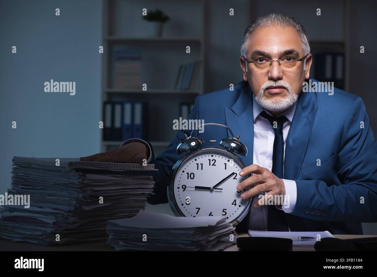 Old employee working late in the office Stock Photo