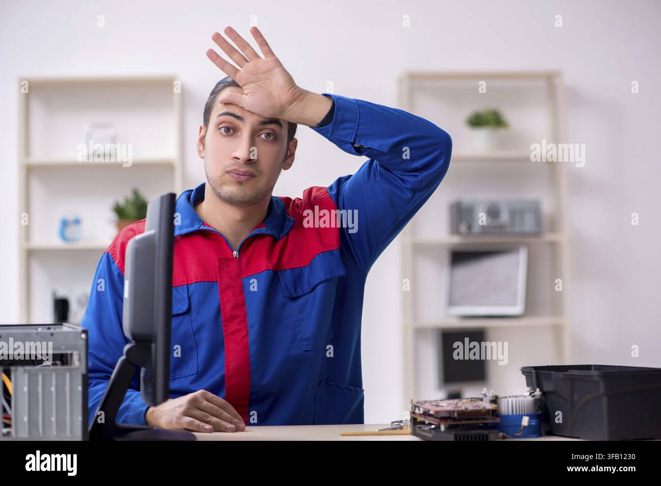 Young male mechanic repairs computer PC Stock Photo