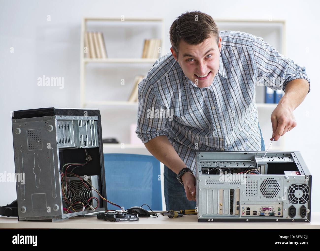 The young technician repairs computers in the workshop Stock Photo