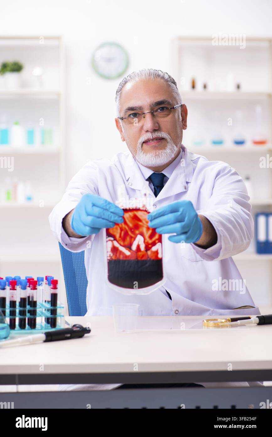 Old chemist working in laboratory Stock Photo