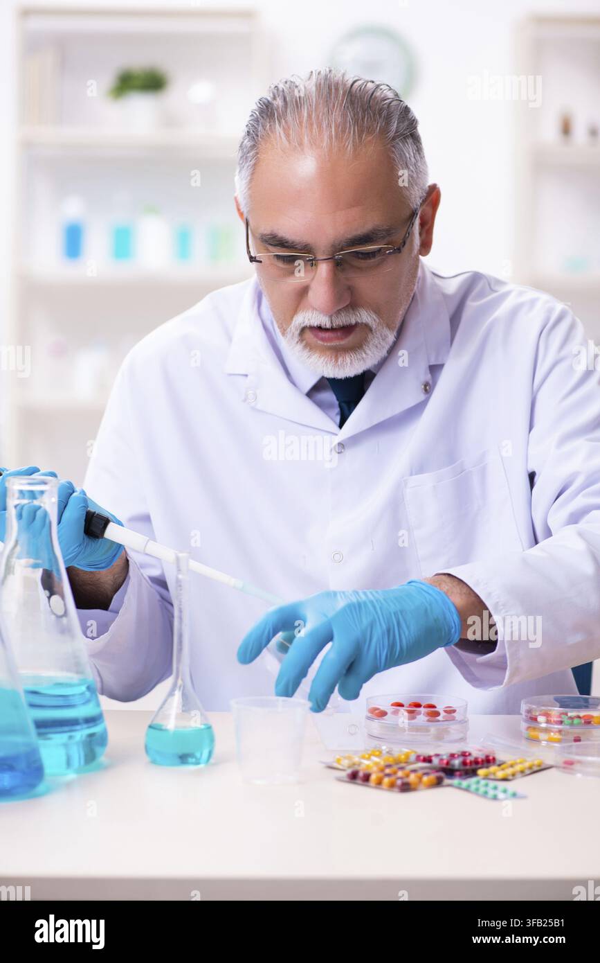 Old chemist working in laboratory Stock Photo