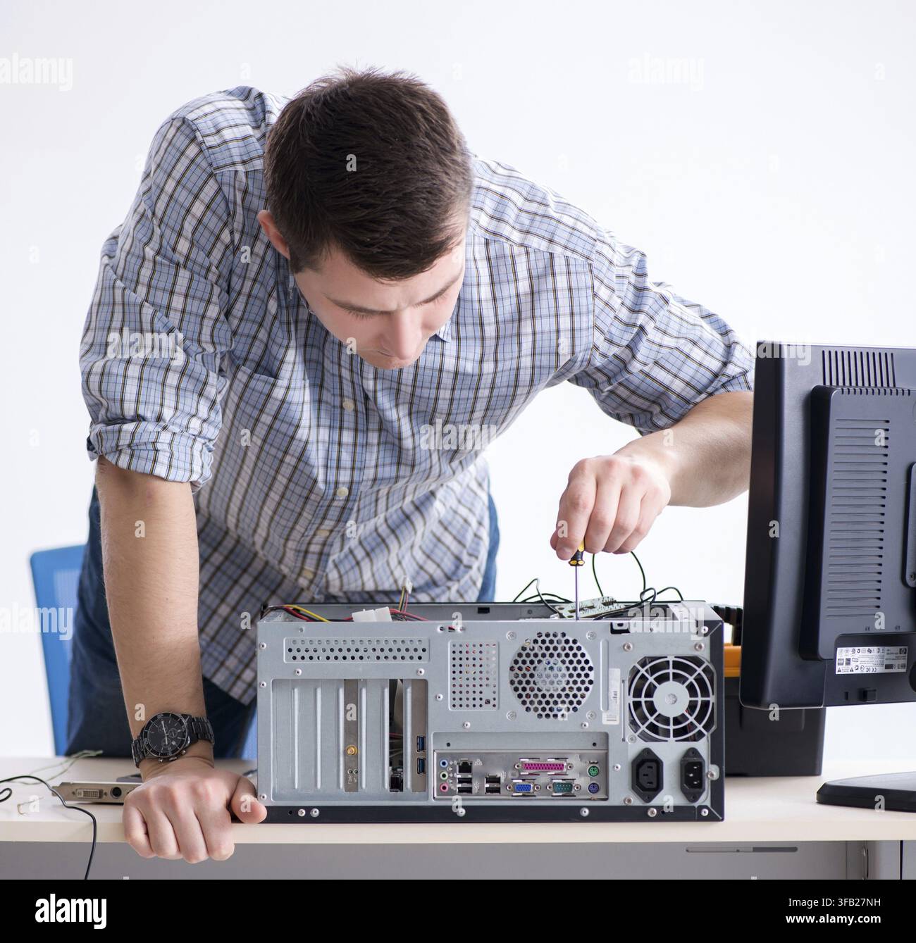 The young technician repairs computers in the workshop Stock Photo