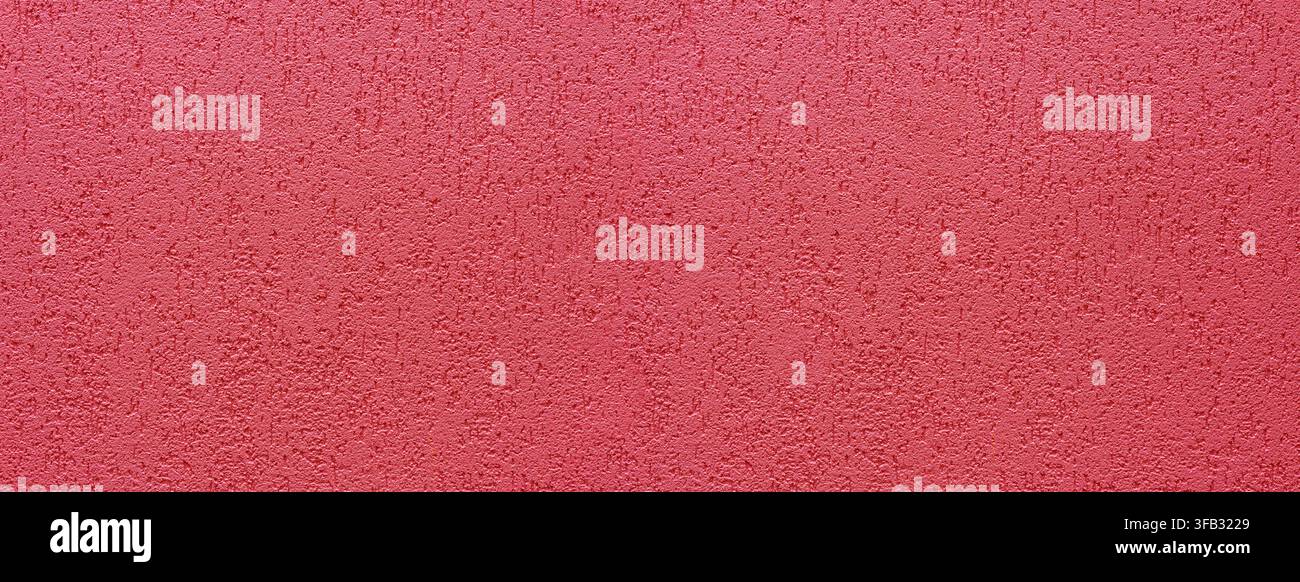 Red rough plaster wall showing textured granular surface for backgrounds Stock Photo