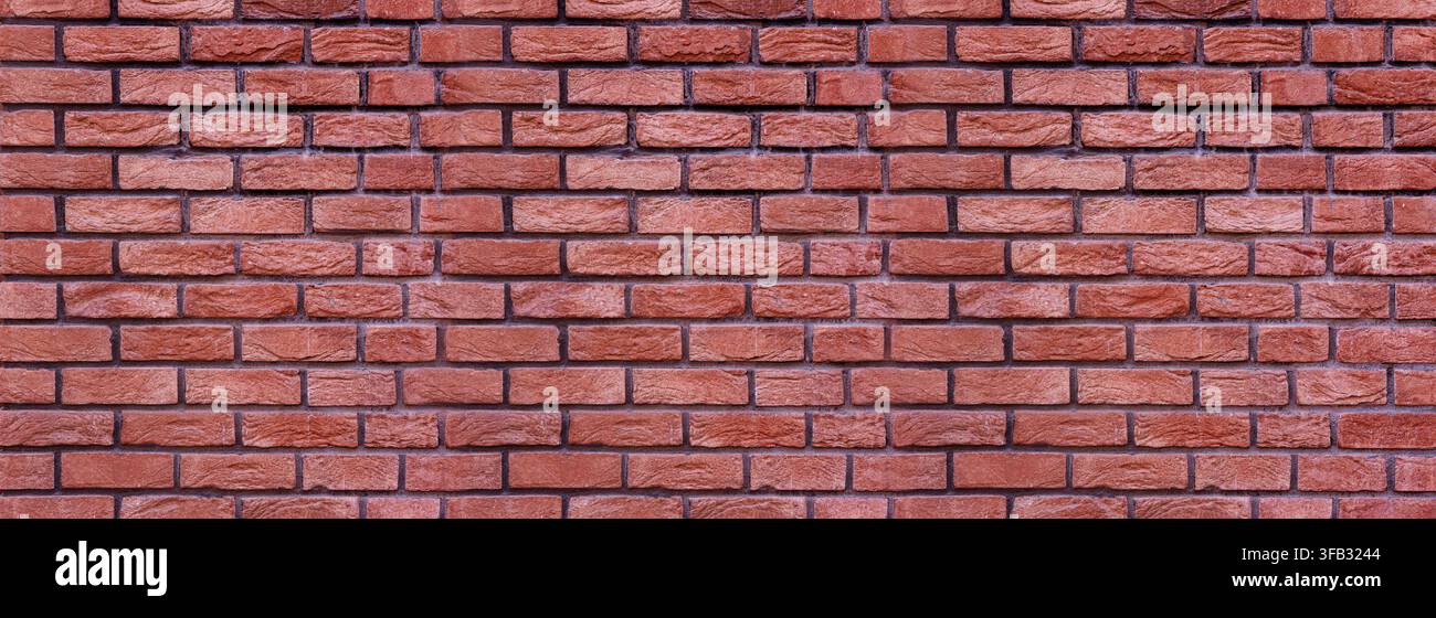 Red brick wall displaying a textured surface and repeating pattern Stock Photo