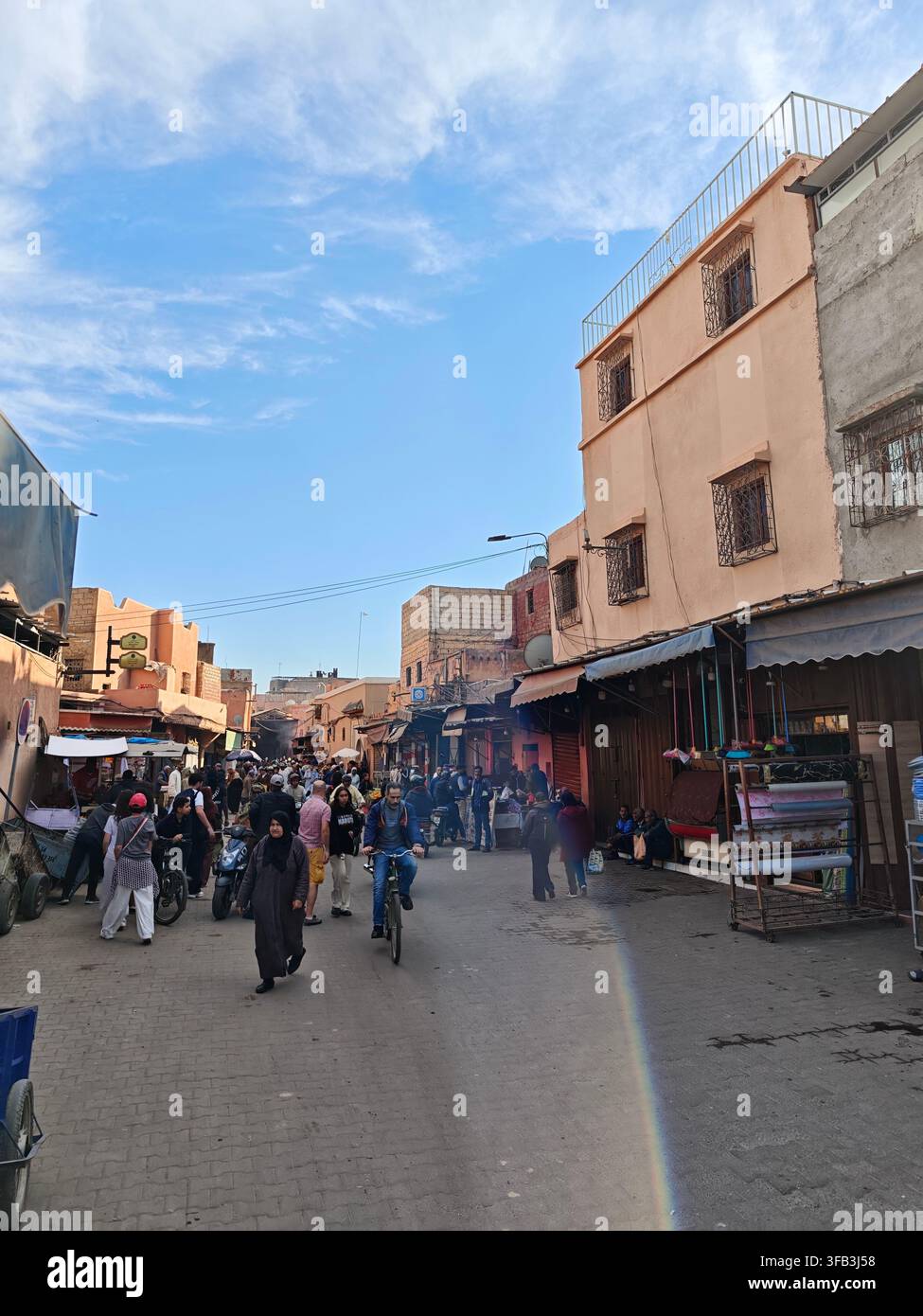 Busy traditional market streets and souks in Marrakech, Morocco, with pedestrians, local shops, motorcycles and traditional Moroccan architecture. - Smartphone Captured Stock Image