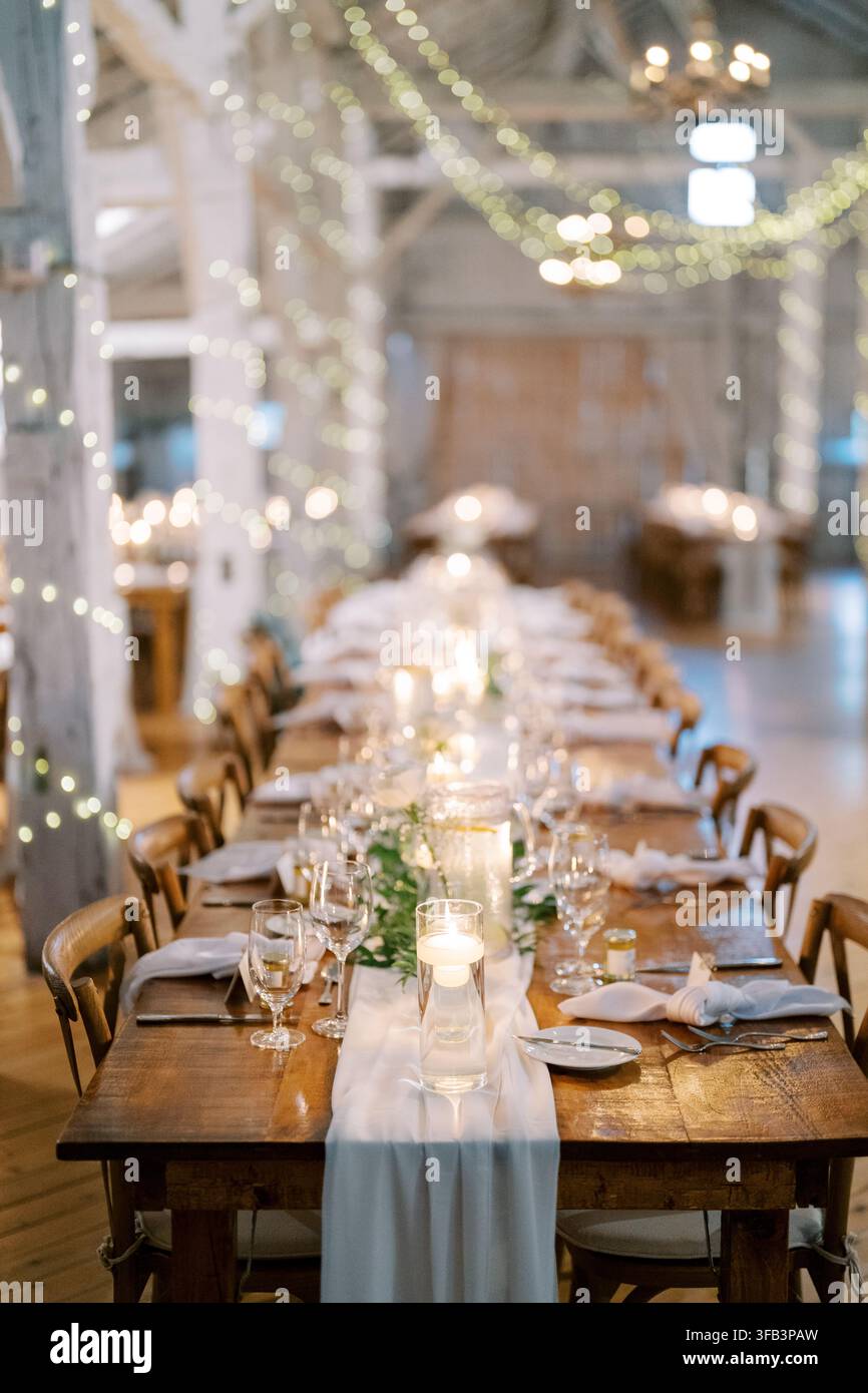 Elegant wedding dinner setup in rustic barn Stock Photo