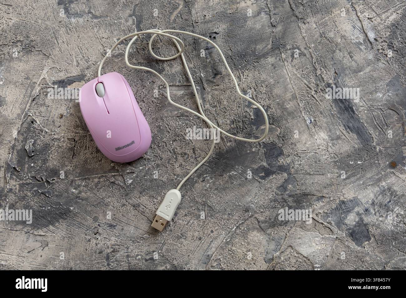 Microsoft Compact Optical Mouse 500 v2.0 USB connected unusually in pink on a grey textured background and though American made in China. Stock Photo