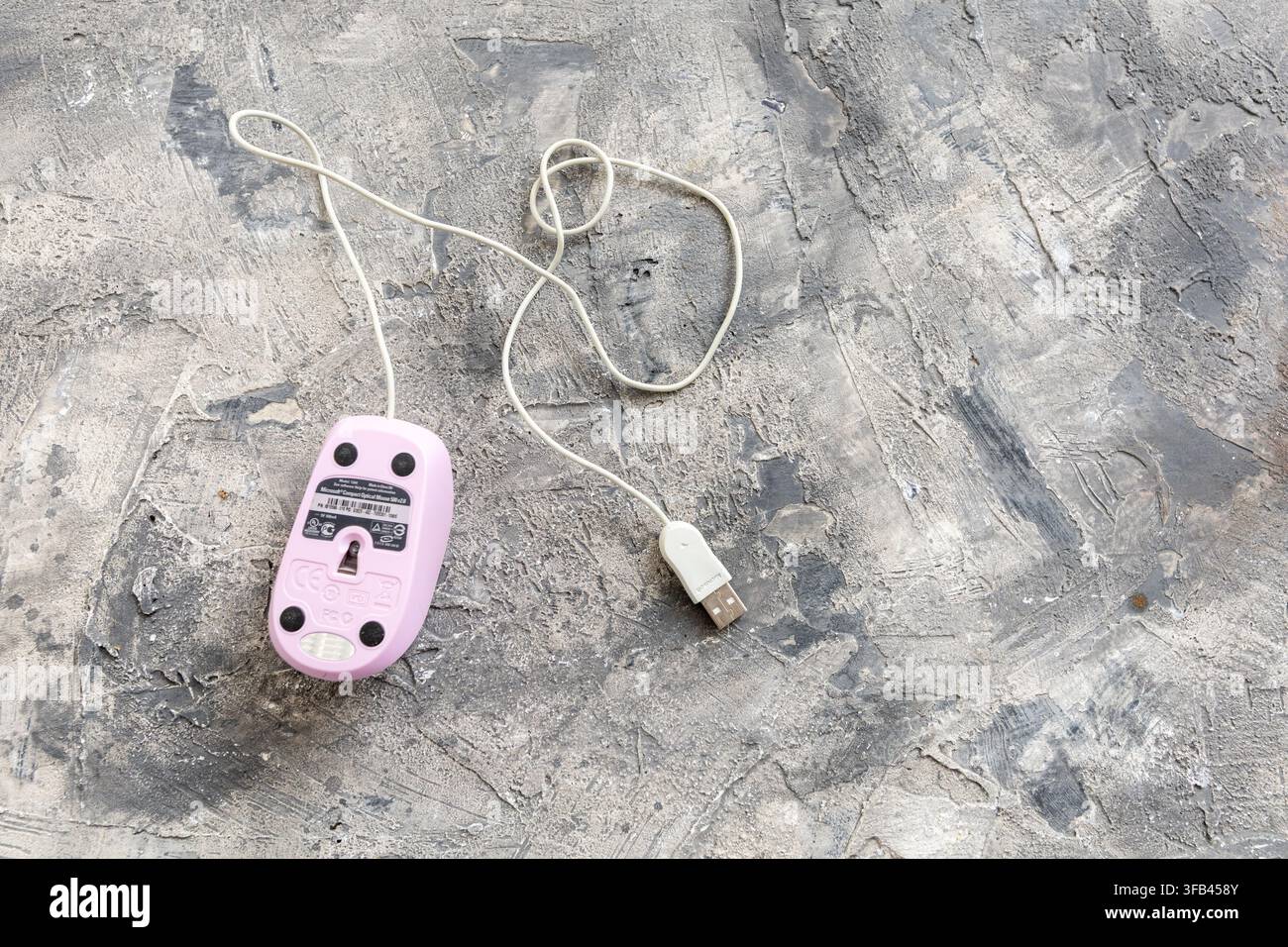 Microsoft Compact Optical Mouse 500 v2.0 USB connected unusually in pink on a grey textured background and though American made in China. Stock Photo